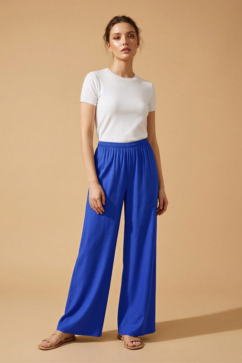 AI on-model catalogue photo, cobalt blue wide-leg trousers on a plain studio backdrop